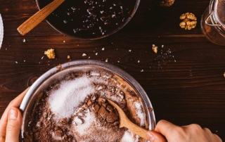 Closeup of baking ingredients for chocolate brownies artistically displayed on a wooden countertop.