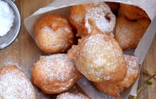 Scrumptious golden brown French beignets lightly dusted with powdered sugar as made by Chef Philippe in the mystery novel ROLL.